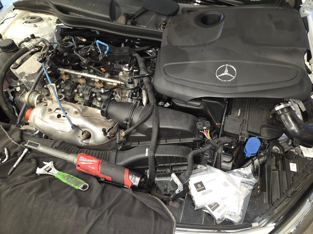 A3 Auto mobile mechanic performing a fuel injector replacement on a Mercedes engine